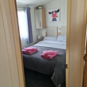 1 Schlafzimmer mit 2 rosa Handtüchern auf einem Bett in der Unterkunft Nicks & Carmels by the sea in Heysham