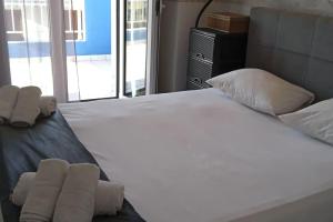 a large white bed with two rolled towels on it at Vasia's maisonette in Nea Fokea