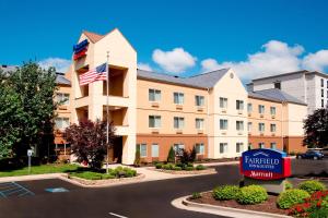 an exterior view of a hotel with an american flag at Fairfield Inn & Suites by Marriott Bloomington in Bloomington