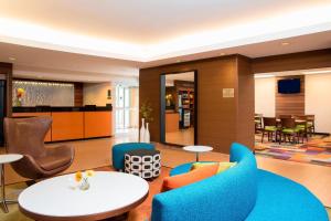 布盧明頓的住宿－Fairfield Inn & Suites by Marriott Bloomington，酒店大堂设有蓝色椅子和桌子