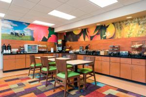 une grande cuisine avec des tables et des chaises dans une cafétéria dans l'établissement Fairfield Inn & Suites by Marriott Bloomington, à Bloomington