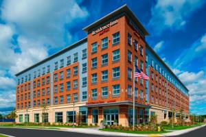 a red brick building with an american flag on it at Residence Inn by Marriott Boston Needham in Needham