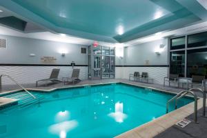 a large pool with blue water in a building at Residence Inn by Marriott Boston Needham in Needham