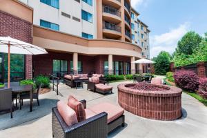 un patio con muebles y una hoguera frente a un edificio en Courtyard by Marriott Atlanta Buford Mall of Georgia en Buford