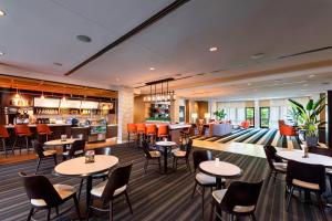 a restaurant with tables and chairs and a bar at Courtyard by Marriott Atlanta Buford Mall of Georgia in Buford