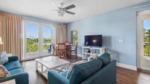 a living room with two blue couches and a tv at Laketown Wharf #101 by Nautical Properties Vacation Rentals in Panama City Beach