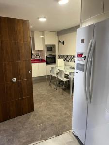 a kitchen with a white refrigerator and a table at Preciosa casa soleada en mirador albaicin in Granada