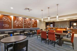 a dining room with tables and chairs and a bar at TownePlace Suites by Marriott Alexandria in Alexandria