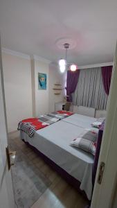 una camera con un grande letto e tende viola di شقة مفروشة في اسطنبول Furnished Apartment in Istanbul a Esenyurt