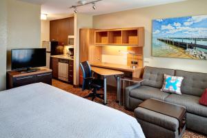 a hotel room with a bed and a couch and a kitchen at TownePlace Suites by Marriott Detroit Troy in Troy