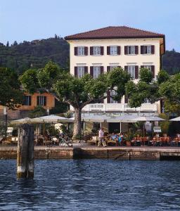 ein großes Gebäude neben einem Wasserkörper in der Unterkunft La Vittoria Boutique Hotel in Garda