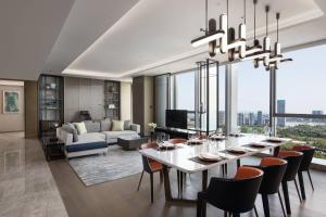 成都市にあるCourtyard by Marriott Chengdu Southのテーブルと椅子のあるダイニングルームとリビングルーム