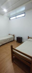 two beds in a room with a window at Casa en colonia para 7 personas in Colonia del Sacramento
