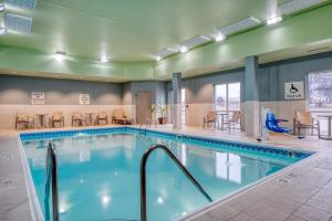 a pool in a hotel with chairs and tables at Holiday Inn Express Troy by IHG in Troy