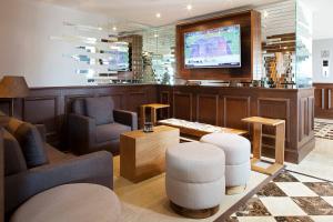 a lobby with a waiting area with a tv and chairs at Villahermosa Marriott Hotel in Villahermosa