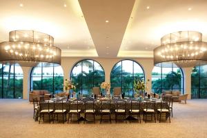 um salão de banquetes com mesas e cadeiras e janelas grandes em Villahermosa Marriott Hotel em Villahermosa