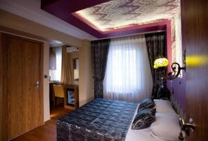 a bedroom with a bed with a purple ceiling at Şirin Hotel in Istanbul