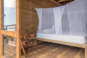 uma cama com uma rede mosquiteira num quarto em Mendihuaca Surf Camp em Guachaca