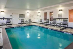 una gran piscina con sillas y mesas en Fairfield Inn & Suites by Marriott Austin Parmer Tech Ridge en Austin