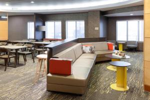 a lobby with a couch and tables and chairs at SpringHill Suites Columbus in Columbus