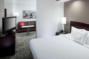 a hotel room with a bed and a tv at SpringHill Suites Columbus in Columbus