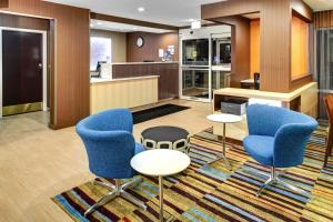 a hotel lobby with blue chairs and a counter at Fairfield Inn and Suites by Marriott Atlanta Suwanee in Suwanee
