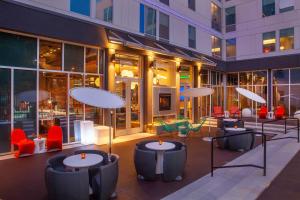 a courtyard with tables and chairs and a building at Aloft Florence in Florence