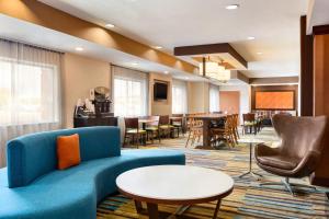 a living room with a couch and chairs and tables at Fairfield Inn & Suites by Marriott Toledo Maumee in Maumee