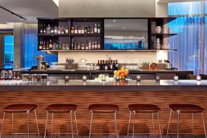 un bar con cuatro taburetes en un restaurante en AC Hotel by Marriott Sunnyvale Cupertino, en Sunnyvale