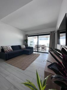 sala de estar con sofá azul y mesa en Casa Nordeste con piscina Casilla de Costa, en La Oliva