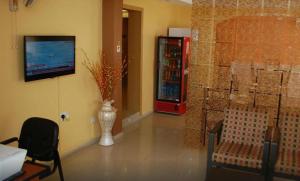 uma sala de estar com televisão e um vaso na parede em Adis Hotels Ibadan em Ibadan