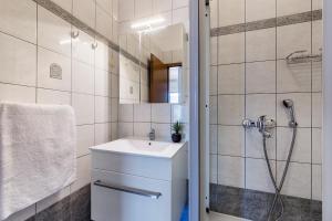 uma casa de banho com um lavatório e um chuveiro em Apartments with a parking space Rabac, Labin - 9652 em Rabac