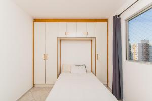 um quarto com uma cama e uma janela em Rental São José - Acomodações Residenciais em São José