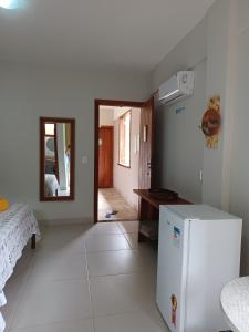 a kitchen with a white refrigerator in a room at Manjuba Pousada - Taipu de Fora in Barra Grande