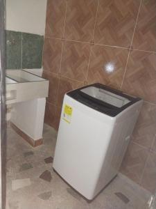 a toilet in a bathroom next to a sink at Los balcones l in Medellín