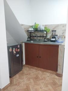 a kitchen with a sink and a refrigerator at Los balcones l in Medellín