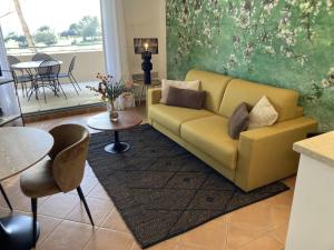 a living room with a yellow couch and a table at Magnifique Vue CLIM LINGE Golf Saumane 6P Piscine Tennis in Saumane-de-Vaucluse