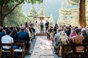 una novia y un novio caminando por el pasillo en su ceremonia de boda en Redwoods River Resort & Campground, en Leggett