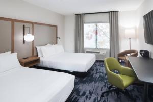 a hotel room with two beds and a desk and a chair at Fairfield Inn & Suites by Marriott Savannah I-95 North in Port Wentworth