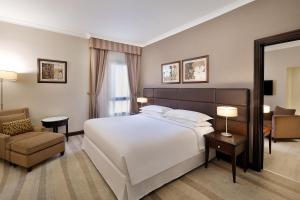 a bedroom with a large white bed and a chair at Sheraton Riyadh Hotel & Towers in Riyadh +58 photos