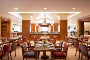 un restaurante con mesas y sillas y un bar en Sheraton Riyadh Hotel & Towers en Riad