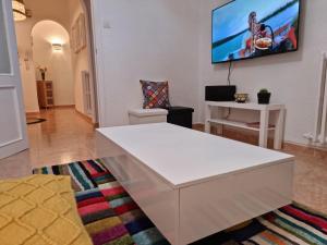 sala de estar con mesa blanca y TV en la pared en Casa Roman SPORT, en León