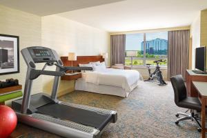 a hotel room with a bed and a treadmill at The Westin Chicago North Shore in Wheeling