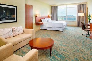 a hotel room with a bed and a couch and a table at The Westin Chicago North Shore in Wheeling +55 photos