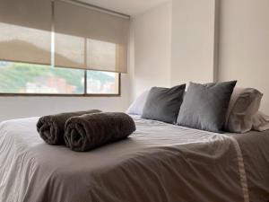 卡利的住宿－Gigi House，一张带两条毛巾的床和窗户