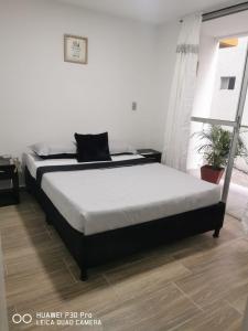 een slaapkamer met een bed en een raam bij Hermoso Apartamento en Circasia, Quindío. in Circasia