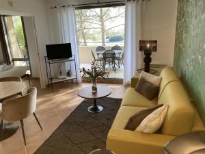 - un salon avec un canapé jaune et une table dans l'établissement Magnifique Vue CLIM LINGE Golf Saumane 6P Piscine Tennis, à Saumane-de-Vaucluse