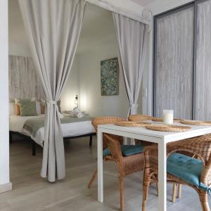 1 dormitorio con mesa blanca, sillas y cama en Apto en el Centro, junto a la playa, Marbella, en Marbella