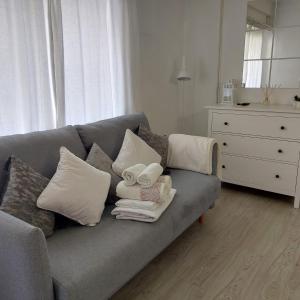 sala de estar con sofá gris con almohadas y tocador en Apto en el Centro, junto a la playa, Marbella, en Marbella