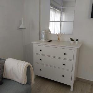 vestidor blanco con espejo en un dormitorio en Apto en el Centro, junto a la playa, Marbella, en Marbella